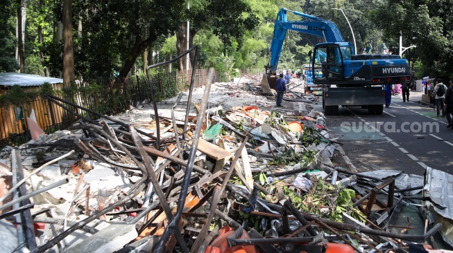Petugas membongkar kios menggunakan eskavator di Pasar Hewan Barito, Jakarta, Senin (27/10/2025). [Suara.com/Alfian Winanto]