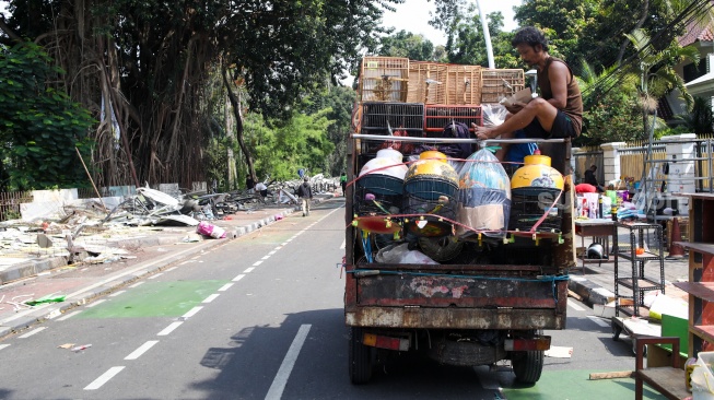 Pedagang membongkar kandang hewan yang dijual di Pasar Hewan Barito, Jakarta, Senin (27/10/2025). [Suara.com/Alfian Winanto]