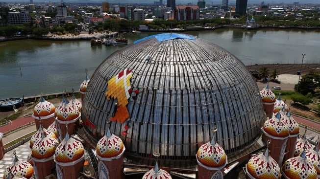 Foto udara pekerja menyelesaikan rehabilitasi atap Masjid 99 Kubah di kawasan Center Point of Indonesia (CPI), Makassar, Sulawesi Selatan, Selasa (28/10/2025). [ANTARA FOTO/Hasrul Said/tom]