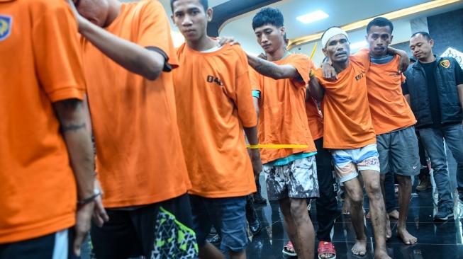 Sejumlah tersangka berjalan keluar ruangan seusai mengikuti ungkap kasus di Mapolresta Samarinda, Kalimantan Timur, Rabu (29/10/2025). [ANTARA FOTO/M Risyal Hidayat/nz]