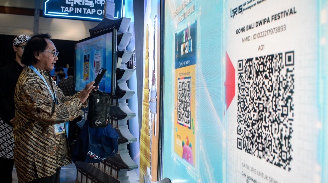 Pengunjung mencoba memindai QRIS Korea Selatan saat Festival Ekonomi dan Keuangan Digital (FEKDI) x Indonesia Fintech Summit & Expo (IFSE) 2025 di Jakarta, Kamis (30/10/2025). [ANTARA FOTO/Putra M. Akbar/YU]
