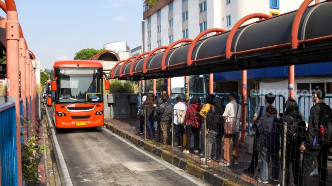 Penumpang menunggu kedatangan Bus Transjakarta di Terminal Blok M, Jakarta, Sabtu (1/11/2025). [Suara.com/Alfian Winanto]