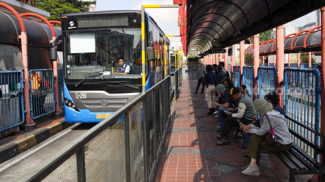 Penumpang menunggu kedatangan Bus Transjakarta di Terminal Blok M, Jakarta, Sabtu (1/11/2025). [Suara.com/Alfian Winanto]
