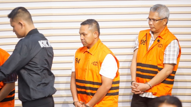 Gubernur Riau Abdul Wahid (tengah) mengenakan rompi oranye khas tahanan KPK usai ditetapkan sebagai tersangka korupsi di Gedung Merah Putih KPK, Jakarta, Rabu (5/11/2025). [Suara.com/Alfian Winanto]