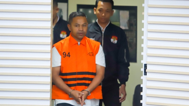 Gubernur Riau Abdul Wahid (tengah) mengenakan rompi oranye khas tahanan KPK usai ditetapkan sebagai tersangka korupsi di Gedung Merah Putih KPK, Jakarta, Rabu (5/11/2025). [Suara.com/Alfian Winanto]