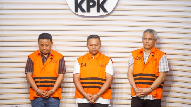 Gubernur Riau Abdul Wahid (tengah) mengenakan rompi oranye khas tahanan KPK usai ditetapkan sebagai tersangka korupsi di Gedung Merah Putih KPK, Jakarta, Rabu (5/11/2025). [Suara.com/Alfian Winanto]