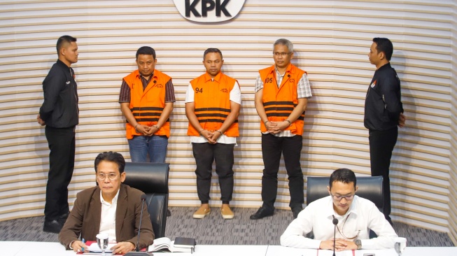 Gubernur Riau Abdul Wahid (tengah) mengenakan rompi oranye khas tahanan KPK usai ditetapkan sebagai tersangka korupsi di Gedung Merah Putih KPK, Jakarta, Rabu (5/11/2025). [Suara.com/Alfian Winanto]