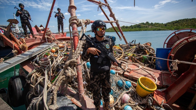 Personel Direktorat Jenderal Pengawasan Sumber Daya Kelautan dan Perikanan (PSDKP) menjaga barang bukti kapal ikan asing (KIA) yang diamankan di Pangkalan PSDKP Batam, Kepulauan Riau, Kamis (6/11/2025). [ANTARA FOTO/Teguh Prihatna/foc]
