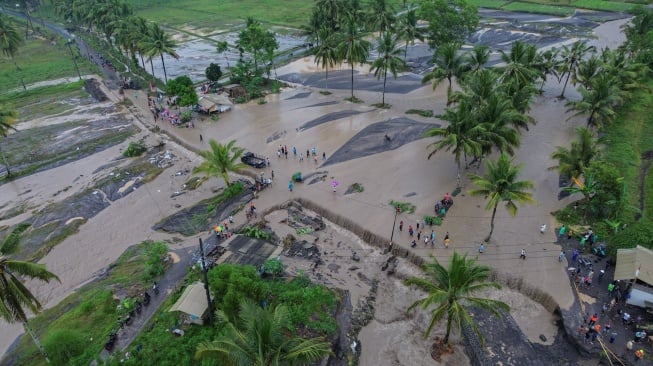 Foto udara warga melintasi lahar hujan Gunung Semeru yang meluap dari Sungai Regoyo di Desa Gondoruso, Kecamatan Pasirian, Lumajang, Jawa Timur, Rabu (5/11/2025). [ANTARA FOTO/Irfan Sumanjaya/nym]