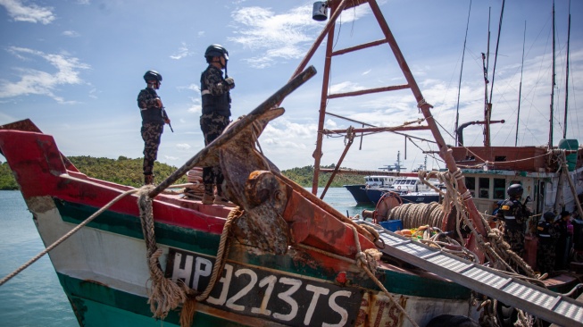 Personel Direktorat Jenderal Pengawasan Sumber Daya Kelautan dan Perikanan (PSDKP) menjaga barang bukti kapal ikan asing (KIA) yang diamankan di Pangkalan PSDKP Batam, Kepulauan Riau, Kamis (6/11/2025). [ANTARA FOTO/Teguh Prihatna/foc]