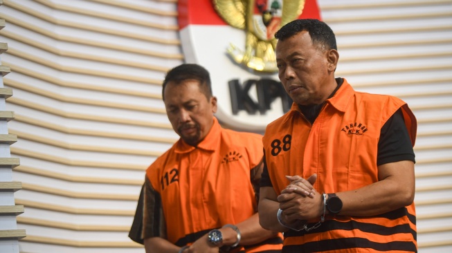 Tersangka selaku Bupati Ponorogo Sugiri Sancoko (kanan) bersama Sekretaris Daerah (Sekda) Kabupaten Ponorogo Agus Pramono (kiri) berjalan usai dihadirkan dalam konferensi pers di gedung Merah Putih KPK, Jakarta, Minggu (9/11/2025). [ANTARA FOTO/Muhammad Adimaja/sgd]