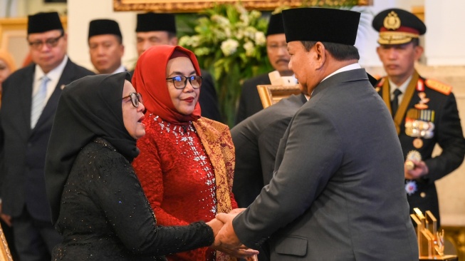 Presiden Prabowo Subianto (kanan) menyalami saudara perempuan almarhum Marsinah, Wijiyati (kiri) dan Marsini (kedua kiri) saat penganugerahan gelar pahlawan nasional di Istana Negara, Jakarta, Senin (10/11/2025). [ANTARA FOTO/Hafidz Mubarak A/nz]