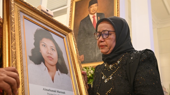 Adik aktivis buruh Marsinah, Wijiyati memandang foto kakaknya usai mengikuti prosesi upacara pemberian gelar pahlawan kepada Marsinah dan sembilan tokoh lainnya di Istana Negara, Jakarta, Senin (10/11/2025). [ANTARA FOTO/Aditya Pradana Putra/nz]
