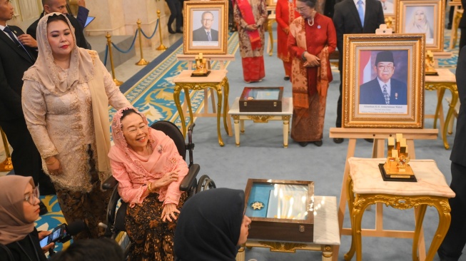Istri almarhum K.H. Abdurrahman Wahid, Sinta Nuriyah (kedua kiri) bersama anaknya Yenny Wahid (kiri) menghadiri penganugerahan gelar pahlawan nasional di Istana Negara, Jakarta, Senin (10/11/2025). [ANTARA FOTO/Hafidz Mubarak A/nz]