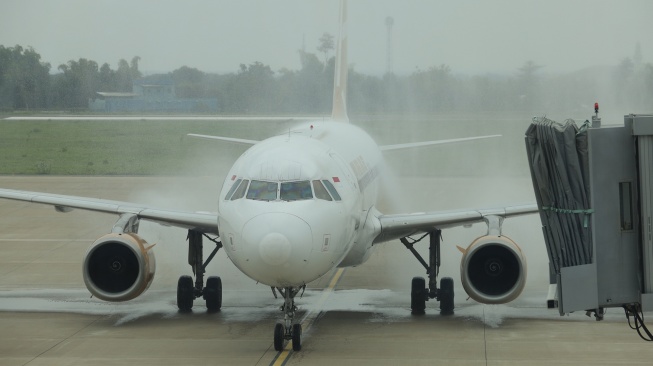 Pesawat Super Air Jet mendapatkan guyuran air saat tradisi water salute atau penyambutan pesawat saat penerbangan perdana di Bandara Dhoho Kediri, Jawa Timur, Senin (10/11/2025). [ANTARA FOTO/Prasetia Fauzani/bar]