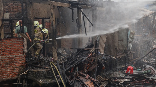 Petugas Dinas Penanggulangan Kebakaran dan Penyelamatan (Gulkarmat) melakukan pemadaman api di permukiman padat penduduk Tambora, Jakarta, Selasa (11/11/2025). [ANTARA FOTO/Ika Maryani/agr] 