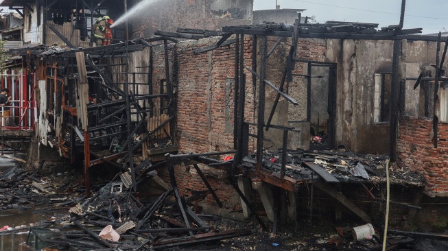 Petugas Dinas Penanggulangan Kebakaran dan Penyelamatan (Gulkarmat) melakukan pemadaman api di permukiman padat penduduk Tambora, Jakarta, Selasa (11/11/2025). [ANTARA FOTO/Ika Maryani/agr]