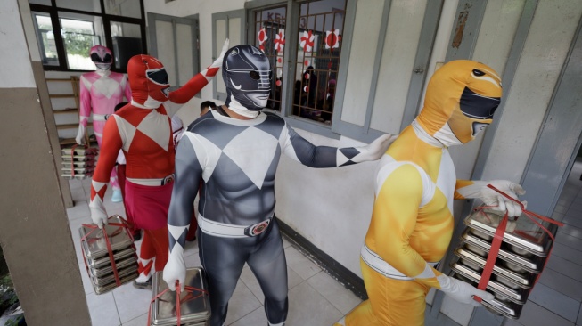 Sejumlah petugas berkostum Power Rangers mengantar Makan Bergizi Gratis (MBG) di SD Negeri Tempurejo 1, Kota Kediri, Jawa Timur, Kamis (13/11/2025). [ANTARA FOTO/Prasetia Fauzani/bar]