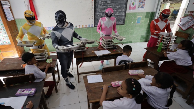 Sejumlah petugas berkostum Power Rangers mengantar Makan Bergizi Gratis (MBG) di SD Negeri Tempurejo 1, Kota Kediri, Jawa Timur, Kamis (13/11/2025). [ANTARA FOTO/Prasetia Fauzani/bar]