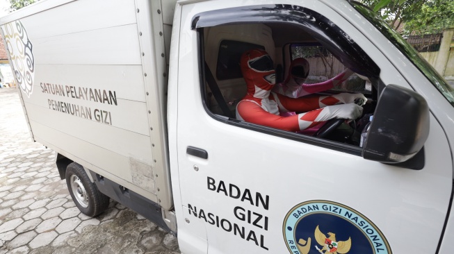 Sejumlah petugas berkostum Power Rangers mengantar Makan Bergizi Gratis (MBG) di SD Negeri Tempurejo 1, Kota Kediri, Jawa Timur, Kamis (13/11/2025). [ANTARA FOTO/Prasetia Fauzani/bar]