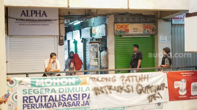 Sejumlah pedagang menutup kiosnya di Pasar Pramuka, Jakarta, Jumat (14/11/2025). [Suara.com/Alfian Winanto]
