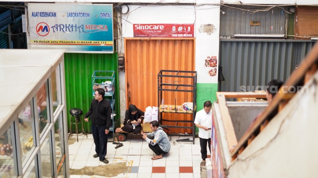 Sejumlah pedagang menutup kiosnya di Pasar Pramuka, Jakarta, Jumat (14/11/2025). [Suara.com/Alfian Winanto]
