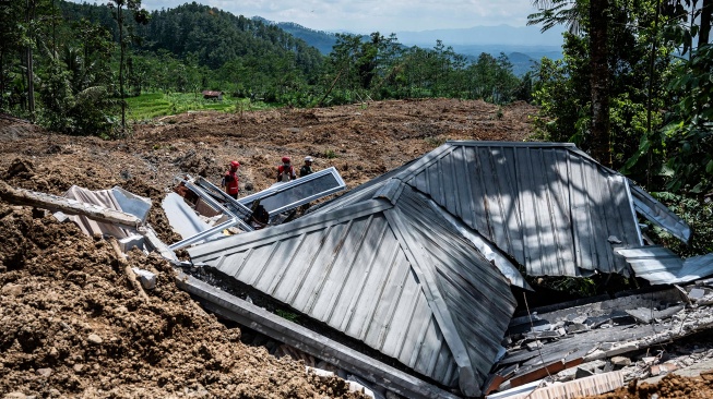 Relawan berjalan di samping puing bangunan yang terdampak bencana tanah longsor di Dusun Situkung, Desa Pandanarum, Kecamatan Pandanarum, Kabupaten Banjarnegara, Jawa Tengah, Selasa (18/11/2025). [ANTARA FOTO/Aprillio Akbar/YU]
