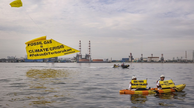 Aktivis Greenpeace membentangkan spanduk saat menggelar aksi damai di kawasan Pembangkit Listrik Tenaga Gas Uap (PLTGU) Muara Karang di Jakarta, Selasa (18/11/2025). [ANTARA FOTO/Dhemas Reviyanto/YU]
