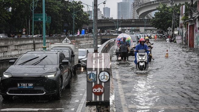 Kendaraan menerobos banjir di Jalan Terusan H. R. Rasuna Said, Jakarta, Selasa (18/11/2025). [ANTARA FOTO/Sulthony Hasanuddin/nym]
