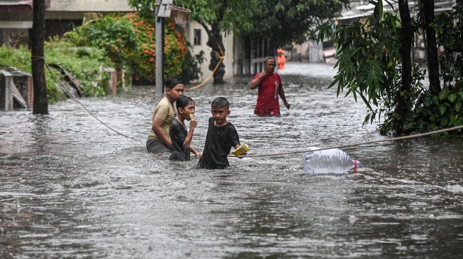 Sejumlah anak bermain saat banjir di Komplek Polri Pondok Karya, Mampang Prapatan, Jakarta, Selasa (18/11/2025). [ANTARA FOTO/Sulthony Hasanuddin/nym]
