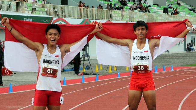 Pelari putra Indonesia Gilang Satria Wibawa (kanan) bersama Rizal Hafid Fuadi (kiri) melakukan selebrasi usai menyelesaikan nomor lari 200 meter kejuaraan Atletik Asia Tenggara 2025 di Stadion Madya Atletik, Deli Serdang, Sumatera Utara, Senin (17/11/2025). [ANTARA FOTO/Yudi Manar/tom]