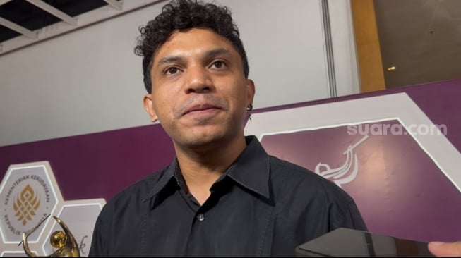 Penyanyi dan pencipta lagu Tabola Bale, Siprianus Bhuka usai memenangkan kategori Pencipta Lagu Pop Terbaik di AMI Awards yang digelar di Ciputra Artprenuer, Jakarta Selatan pada Rabu, 19 November 2025. [Tiara Rosana/Suara.com]