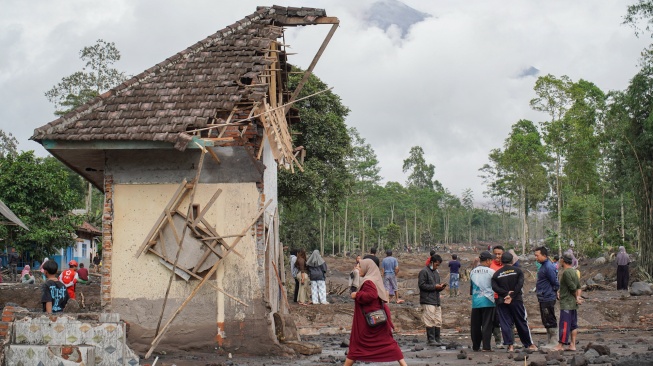 Warga melintasi perkampungan yang terdampak erupsi Gunung Semeru di Desa Supiturang, Lumajang, Jawa Timur, Kamis (20/11/2025). [ANTARA FOTO/Irfan Sumanjaya/nz]