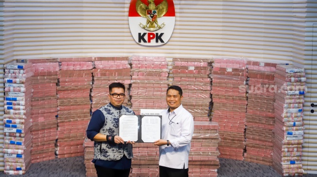 Plt Deputi Penindakan dan Eksekusi KPK Asep Guntur Rahayu (kanan) memberikan berita acara penyerahan hasil rampasan aset hasil korupsi kepada Direktur Utama PT Taspen, Rony Hanityo Aprianto (kiri) di Gedung Merah Putih KPK, Jakarta, Kamis (20/11/2025). [Suara.com/Alfian Winanto]