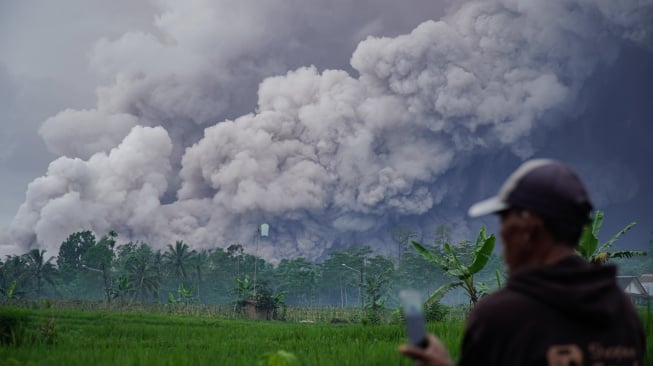 Warga melihat luncuran awan panas Gunung Semeru di Desa Sumberwuluh, Candipuro, Lumajang, Jawa Timur, Rabu (19/11/2025). [ANTARA FOTO/Irfan Sumanjaya/YU]