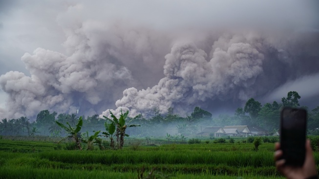 Warga mengabadikan luncuran awan panas Gunung Semeru di Desa Sumberwuluh, Candipuro, Lumajang, Jawa Timur, Rabu (19/11/2025). [ANTARA FOTO/Irfan Sumanjaya/YU]