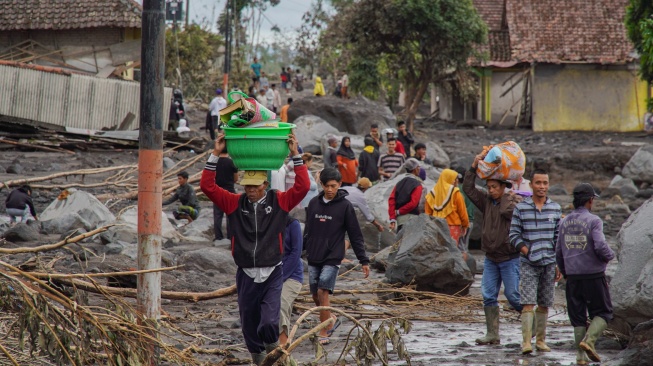 Warga mengevakuasi barang dari rumahnya yang terdampak erupsi Gunung Semeru di Desa Supiturang, Lumajang, Jawa Timur, Kamis (20/11/2025). [ANTARA FOTO/Irfan Sumanjaya/nz]