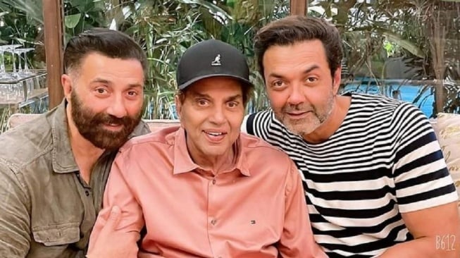 Aktor legendaris India, Dharmendra (tengah) bersama dua putranya yang juga aktor ternama Bollywood; Sunny Deol dan Bobby Deol. Dharmendra meninggal dunia hari ini, Senin (24/11/2025) di usia 89 tahun. [Instagram]