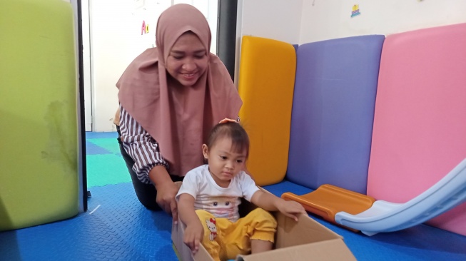 Siti Minar Halimah sedang bermain dengan anaknya di Rumah Anak SIGAP Tanoto Foundation (Suara.com/Chyntia Sami)