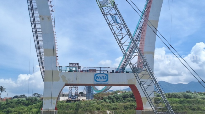 Proses Pembangunan Jembatan Kaca di Bendungan Sukamahi, Puncak, Bogor. [Suara.com/Achmad Fauzi]. 