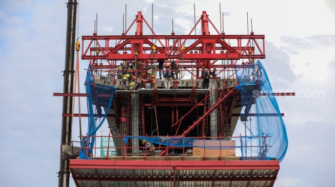 Pekerja menyelesaikan pembangunan proyek Lintas Raya Terpadu (LRT) Jakarta Fase 1B di Jakarta, Rabu (26/11/2025). [Suara.com/Alfian Winanto]