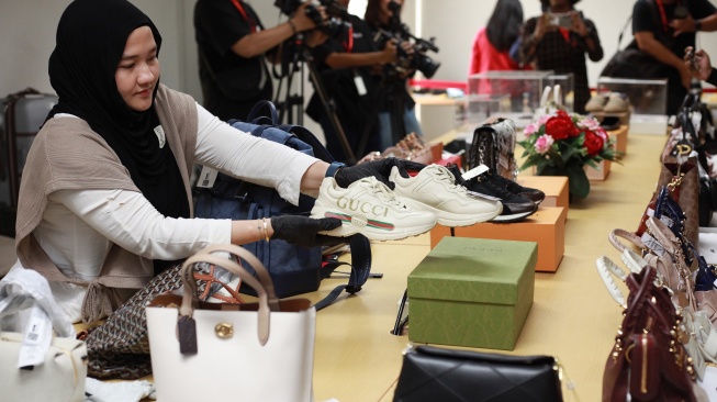 Petugas memperlihatkan sejumlah barang bukti hasil sitaan yang akan dilelang di Rumah Penyimpanan Benda Sitaan Negara (Rupbasan) Komisi Pemberantasan Korupsi di Cawang, Jakarta, Rabu (26/11/2025). [ANTARA FOTO/Reno Esnir/sgd/tom]