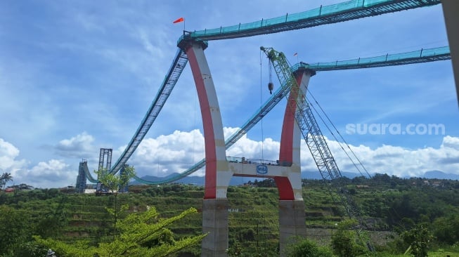 Proses Pembangunan Jembatan Kaca di Bendungan Sukamahi, Puncak, Bogor. [Suara.com/Achmad Fauzi]. 