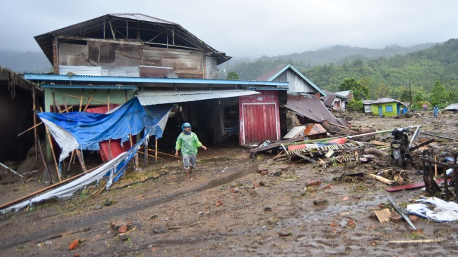 Warga berjalan melewati material longsor di Toboh Tangah, Nagari Malalak Timur, Agam, Sumatera Barat, Kamis (27/11/2025). [ANTARA FOTO/Iggoy el Fitra/YU]