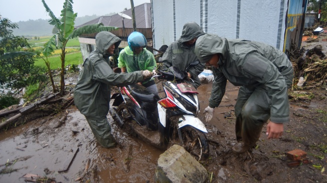 Petugas Brimob Polda Sumbar membantu warga mengevakuasi motor di Toboh Tangah, Nagari Malalak Timur, Agam, Sumatera Barat, Kamis (27/11/2025). [ANTARA FOTO/Iggoy el Fitra/YU]