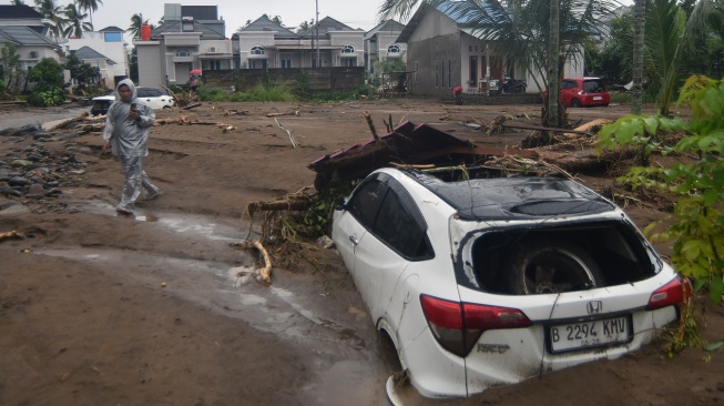 Warga melihat mobil yang tertimbun lumpur akibat banjir bandang di Lubuk Minturun, Padang, Sumatera Barat, Kamis (27/11/2025). [ANTARA FOTO/Iggoy el Fitra/foc]

