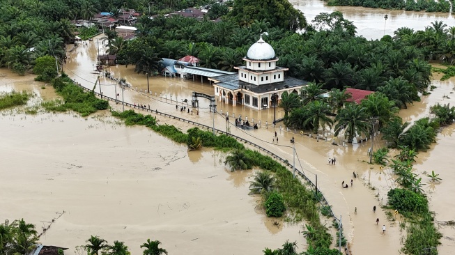 Foto udara pengendara melintasi jalan nasional Medan-Banda Aceh yang terendam banjir di Desa Peuribu, Arongan Lambalek, Aceh Barat, Aceh, Kamis (27/11/2025). [ANTARA FOTO/Syifa Yulinnas/foc]
