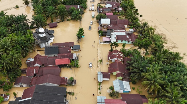 Foto udara pengendara melintasi jalan nasional Medan-Banda Aceh yang terendam banjir di Desa Peuribu, Arongan Lambalek, Aceh Barat, Aceh, Kamis (27/11/2025). [ANTARA FOTO/Syifa Yulinnas/foc]