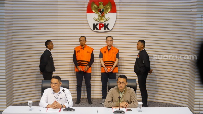 Tersangka kasus dugaan tindak pidana korupsi di lingkungan DJKA Medan, ASN Direktorat Jenderal Keselamatan Perkeretaapian DJKA Kemenhub PPK Balai Teknik Perkeretaapian Medan periode 2021-2024 Muhlis Hanggani Capah (kiri) bersama Komisaris PT Tri Tirta Eddy Kurniawan Winarto (kanan) dihadirkan saat rilis di Gedung Merah Putih, Jakarta, Senin (1/12/2025). [Suara.com/Alfian Winanto]