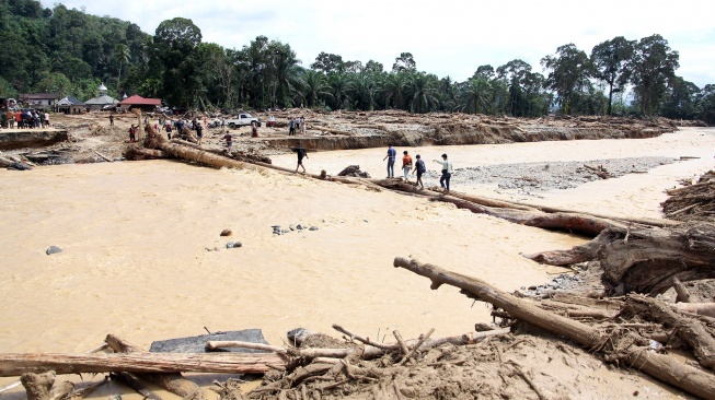 Warga berjalan melintasi sungai dengan jembatan darurat di Desa Aek Garoga, Kecamatan Batang Toru, Kabupaten Tapanuli Selatan, Sumatera Utara, Sabtu (29/11/2025). [ANTARA FOTO/Yudi Manar/bar]